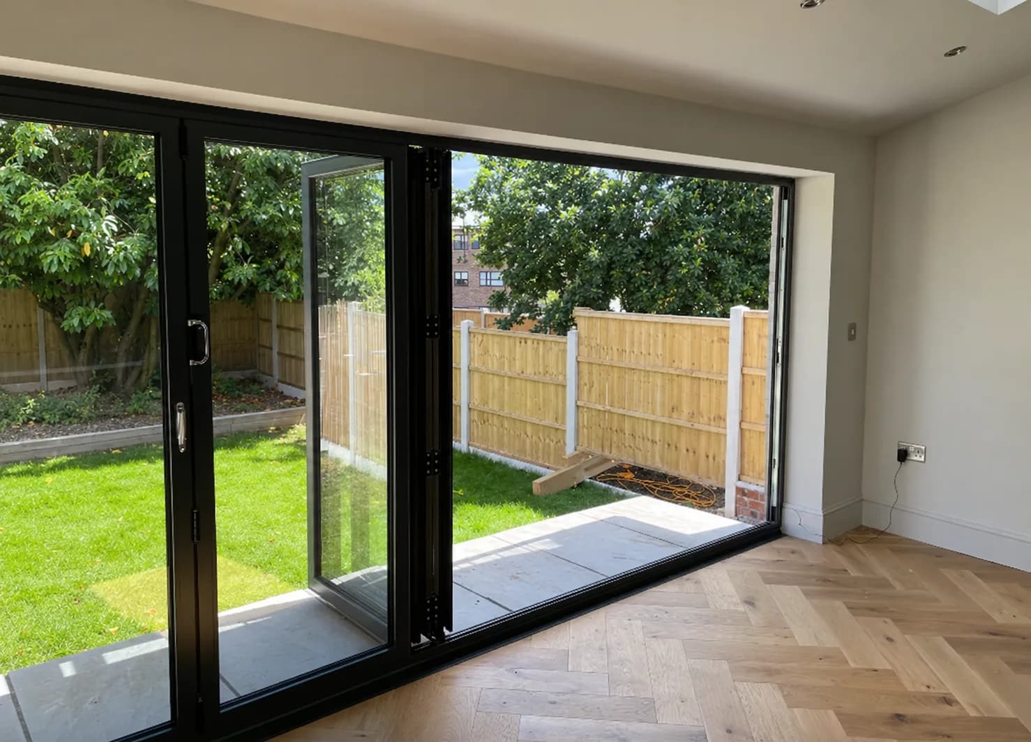 Completed extension with herringbone flooring and wide black framed doors
