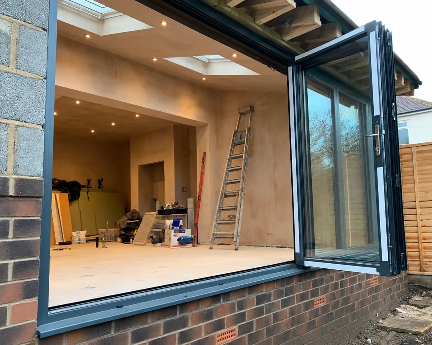 Extension during construction with rooflights, fresh plasterwork and folding doors